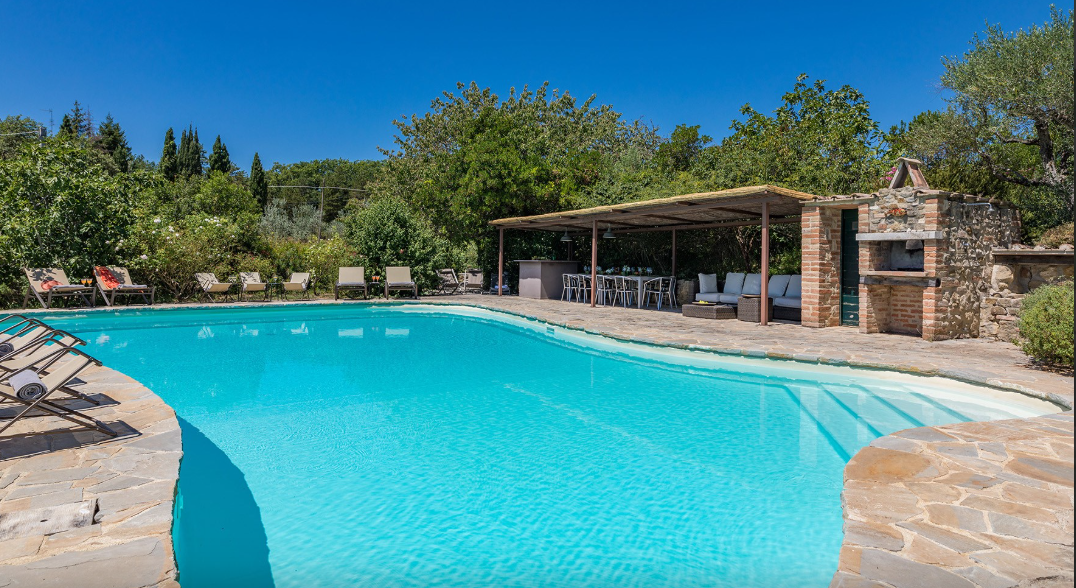 Piscina e zona con lettini, sdraio e salottino